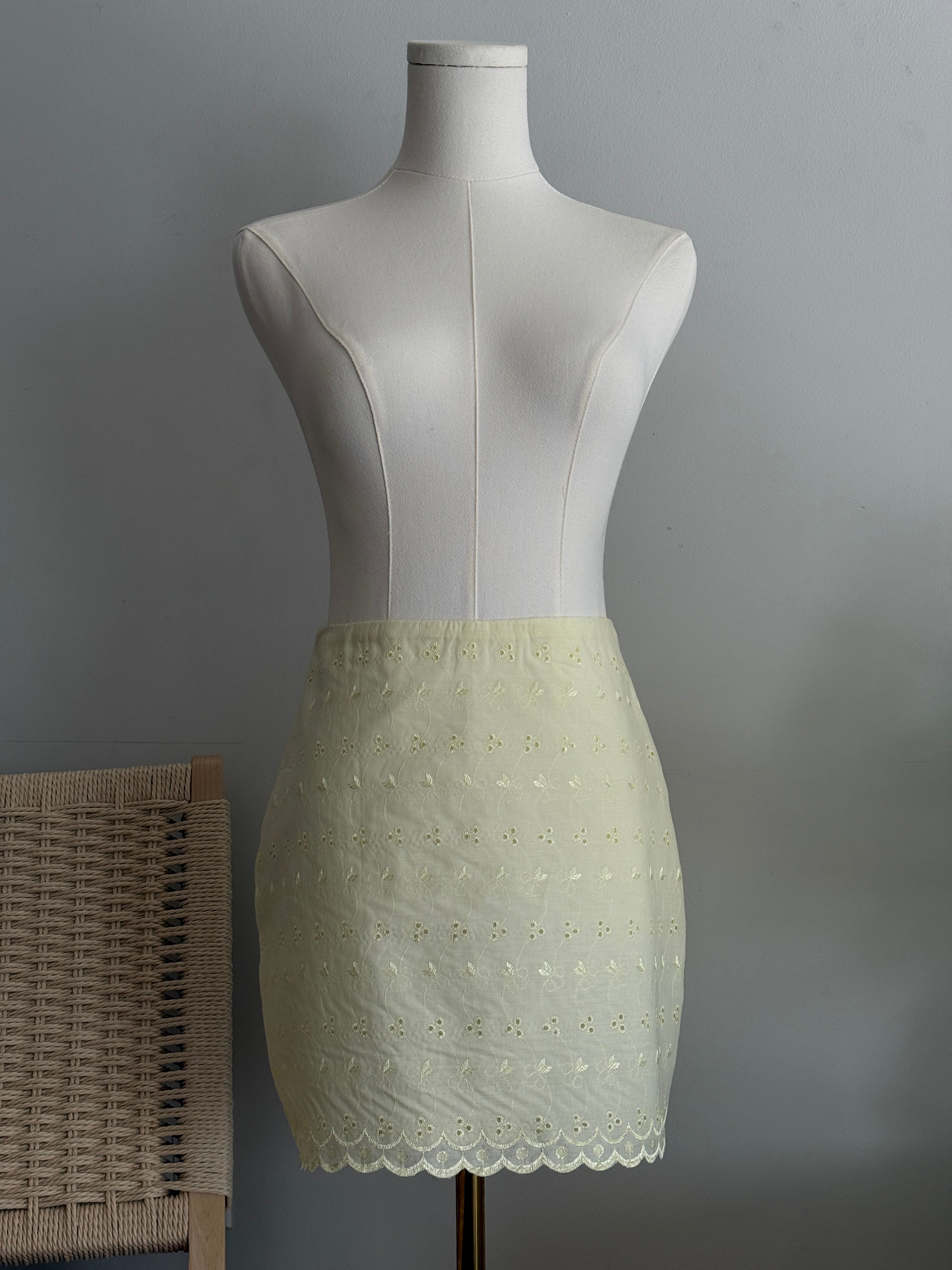 Hoekey cream embroidered mini skirt with delicate floral eyelet pattern, scalloped hemline, and lightweight fabric for a feminine summer look.