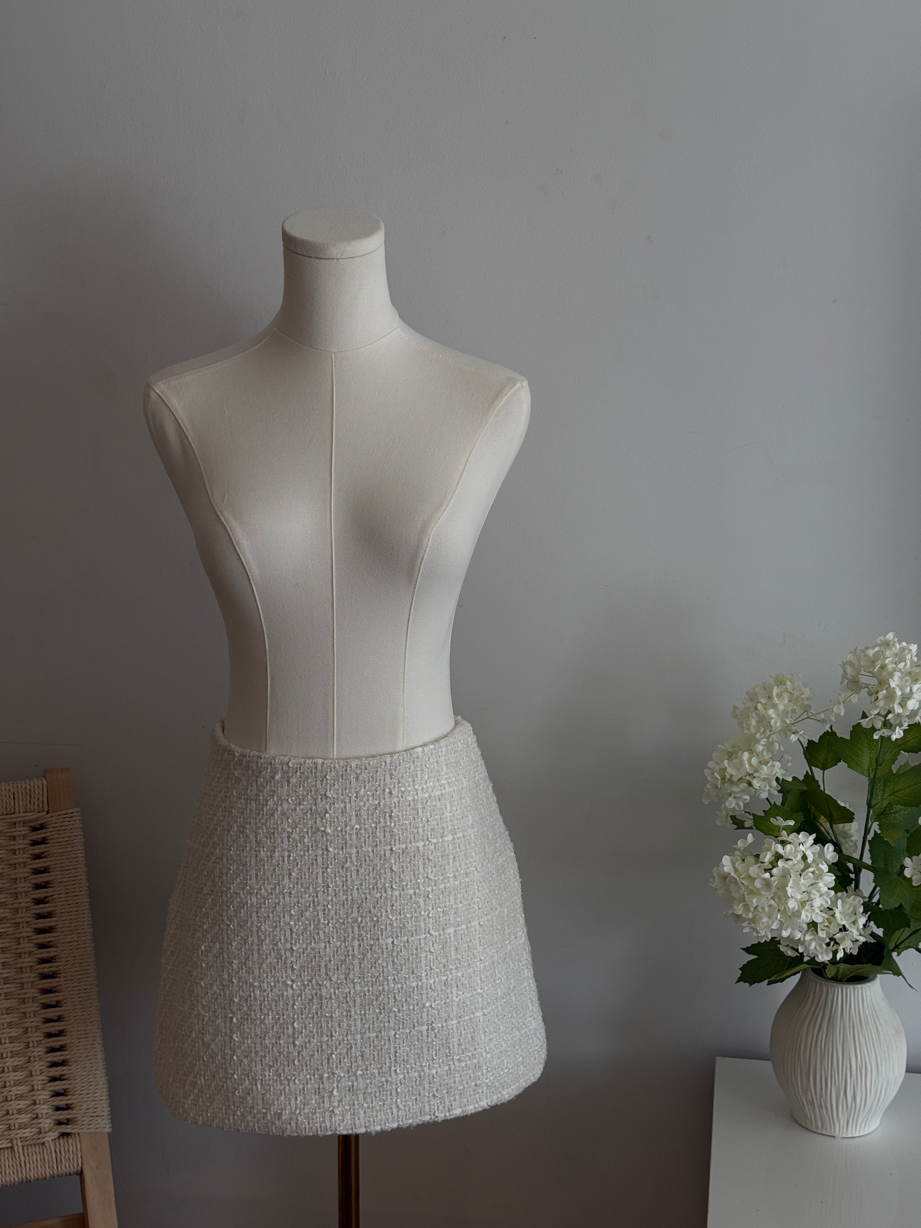 Hoekey ivory tweed mini skirt with textured woven detailing, tailored A-line silhouette, and versatile design for day-to-night wear.