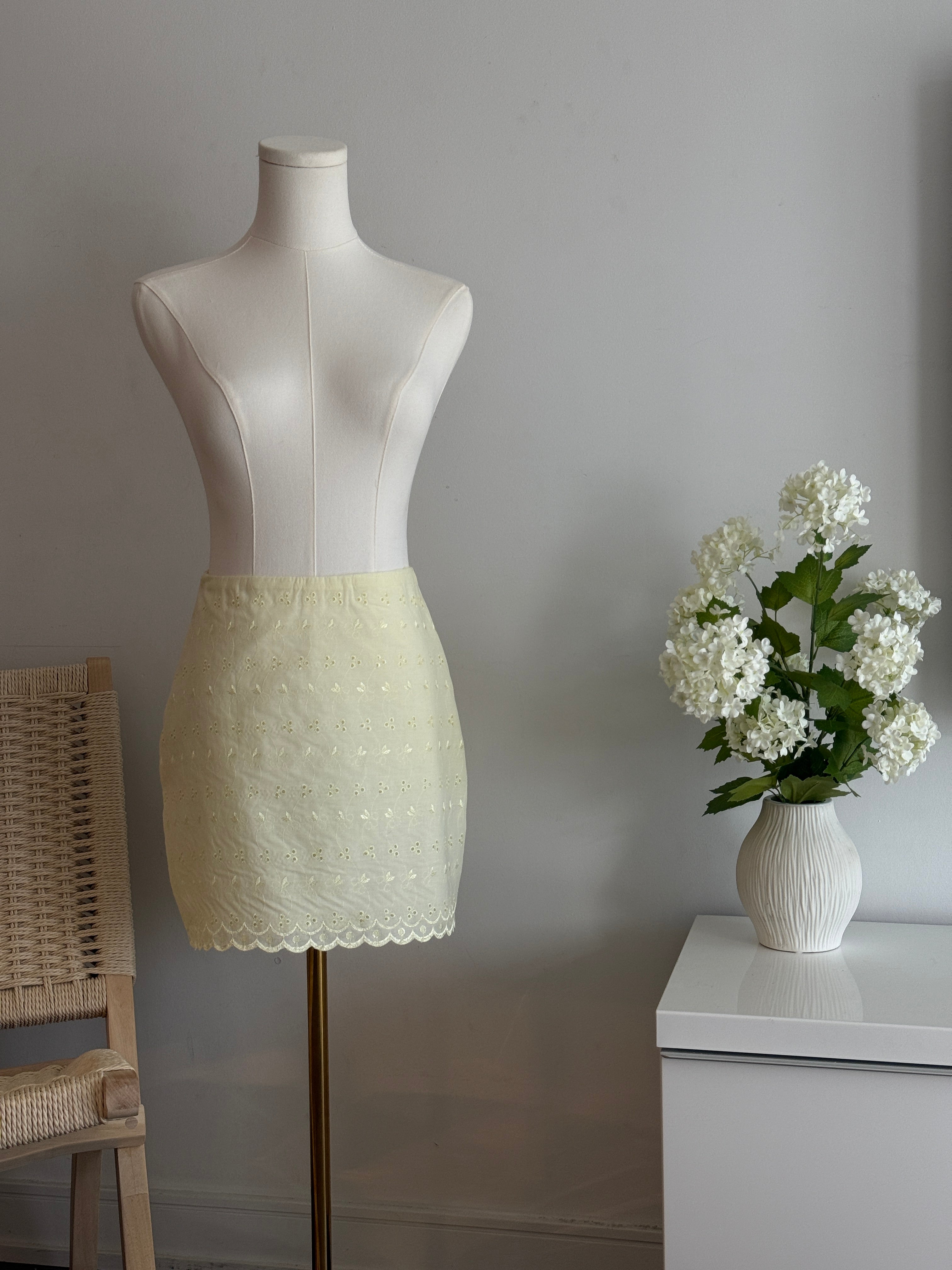 Hoekey cream eyelet mini skirt featuring allover floral embroidery, scalloped edge hem, and airy lightweight fabric for an elegant warm-weather outfit.