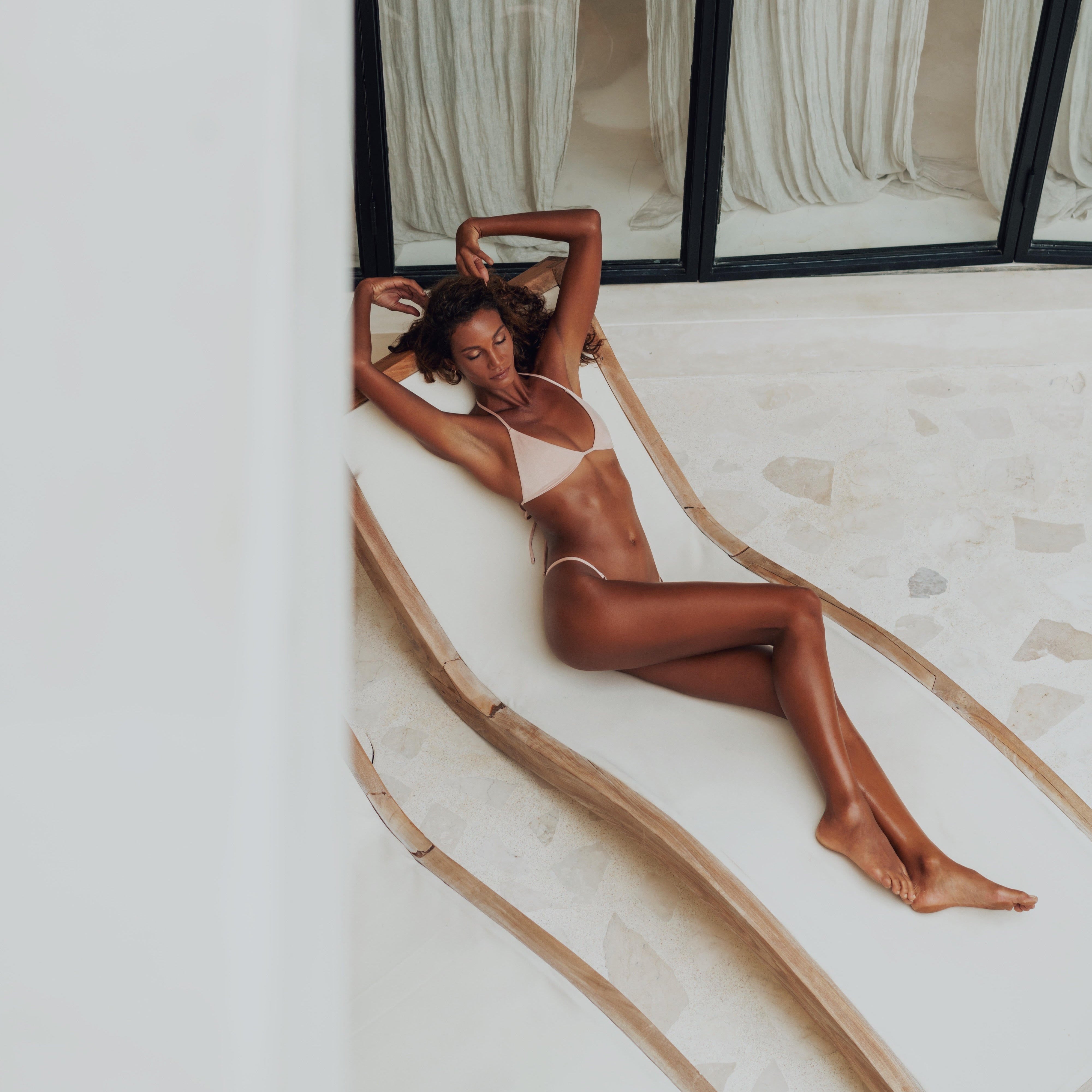 nude triangle bikini with string tie bottoms on a curved wood poolside lounger